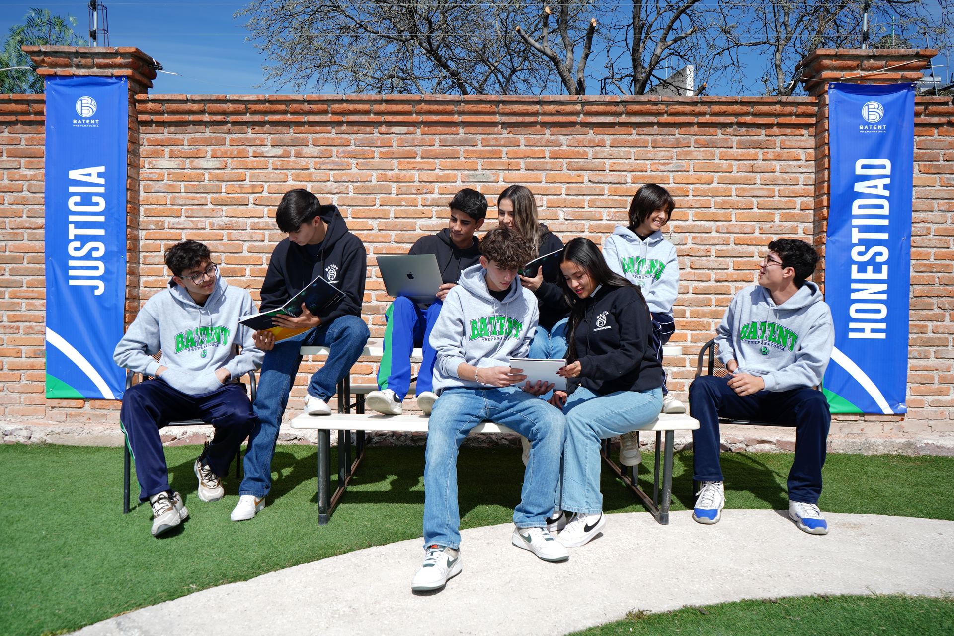 Alumnos de BATENT trabajando en equipo con libretas y laptop