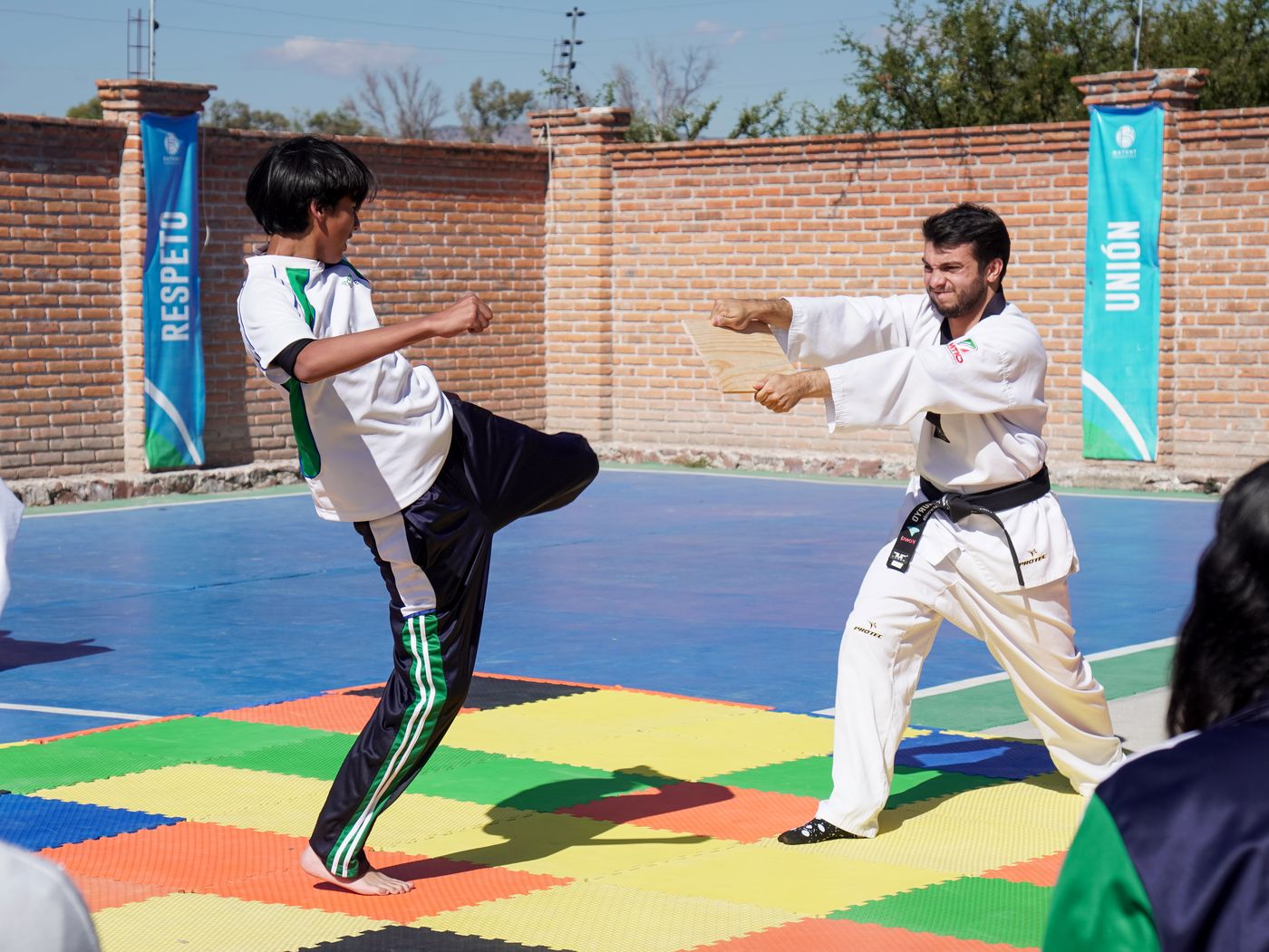 Alumno de BATENT dando una patada en una exhibición de taekwondo